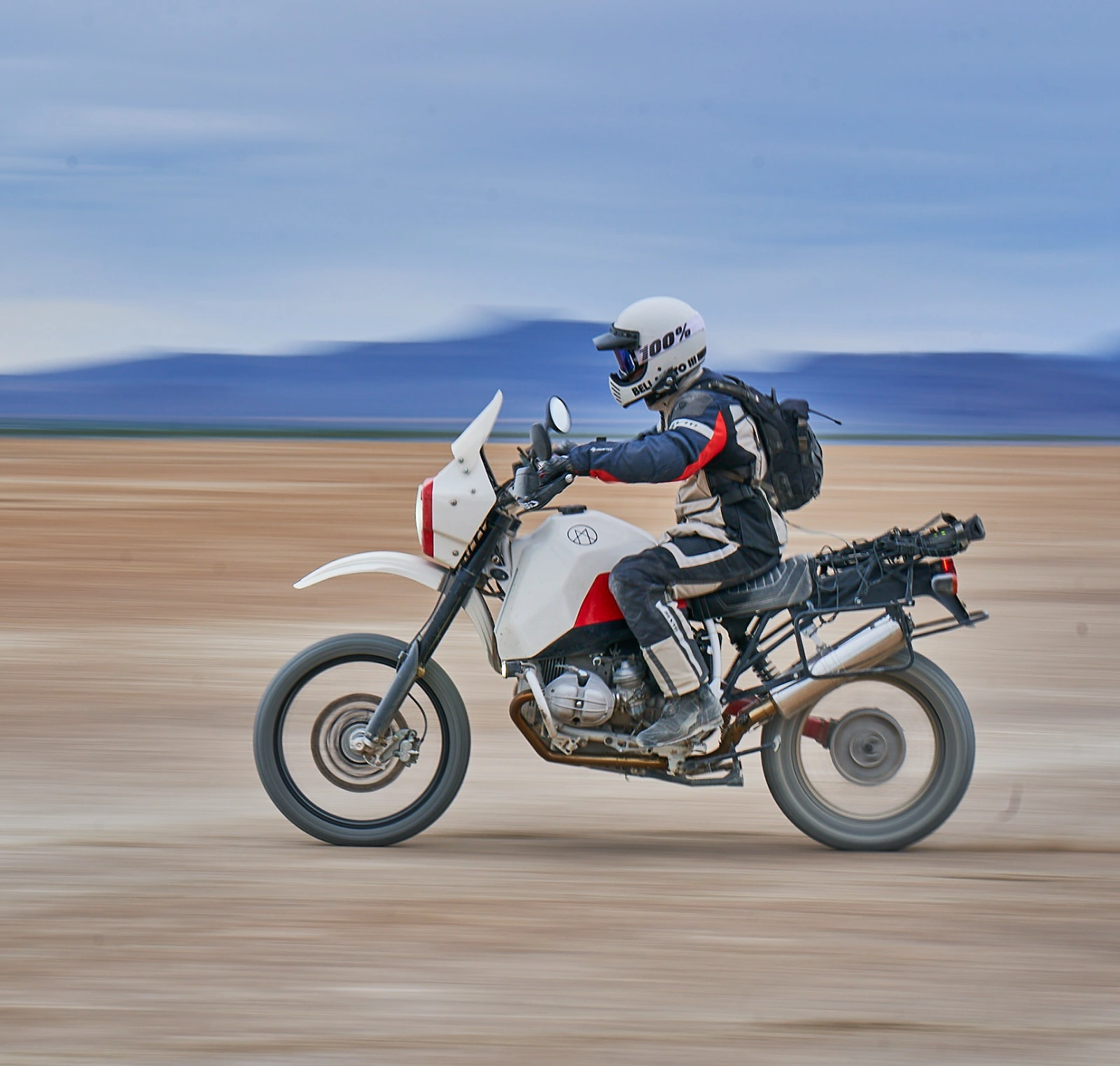 Rider on the white Myth adventure motorcycle crossing an open landscape