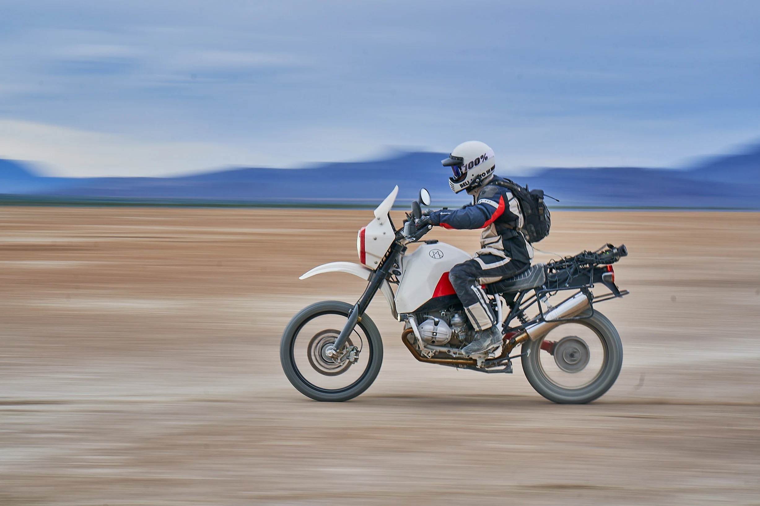 Rider on the white Myth adventure motorcycle crossing an open landscape